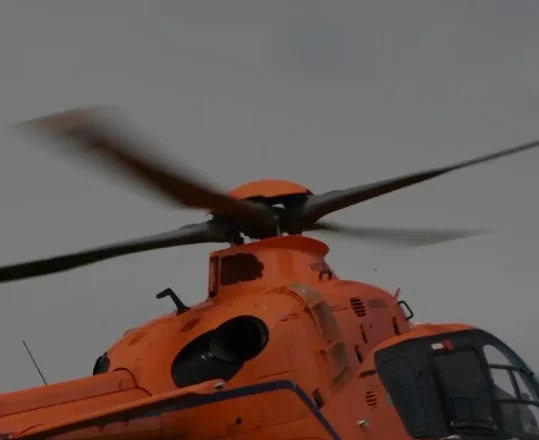 orange helicopter flying low