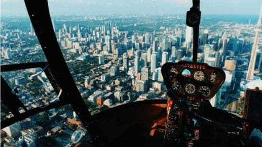 Helicopter cockpit view of a city below.
